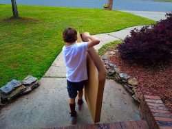 kid moving cardboard