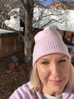 Blonde woman in a pink hat taking a selfie