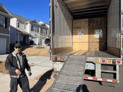 man standing next to loaded freight trailer