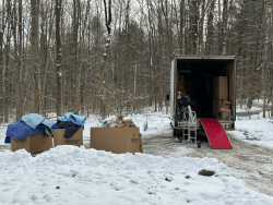 Moving truck with items unloaded in a snowy driveway