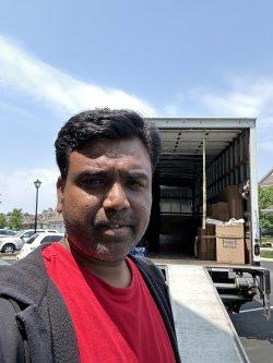 Suresh in fornt of the International Van Lines truck