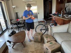 woman standing in living room packing boxes