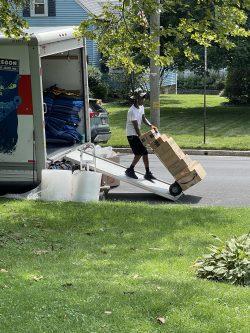 Mover rolling boxes down truck ramp